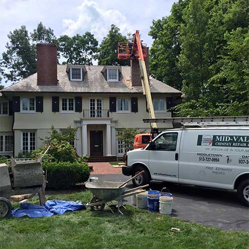 Mid-Valley Chimney Service Truck and Boom Lift in Front of House Repairing Chimney