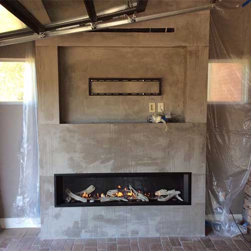 Grey stone gas fireplace with TV mount space above it