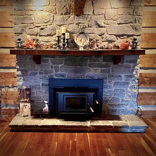 Black wood Burning Insert with stone surround, hearth, and wood mantel
