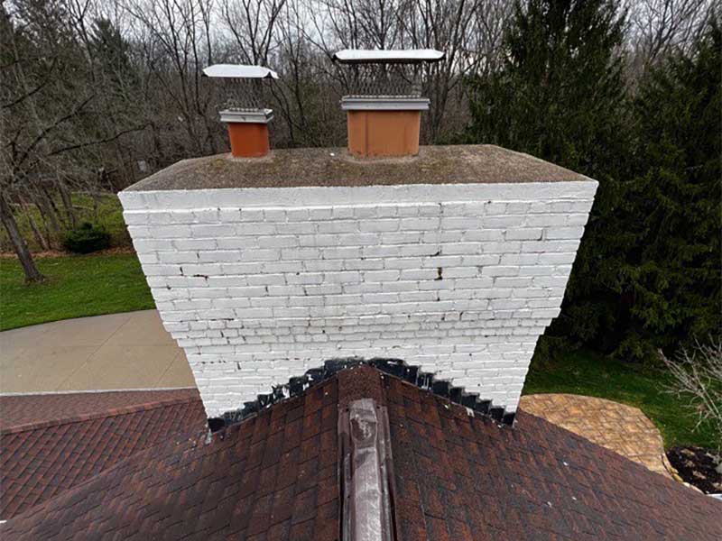 White chimney masonry with deteriorating crown and caps before Complete Grindout and Retuckpoint work