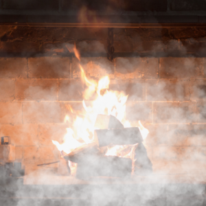 a wood burning fire in a fireplace with smoke pouring out