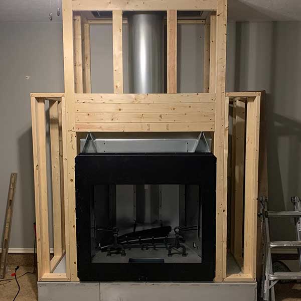 Prefab Chimney during build of surround with ladder to the right and level to the left.