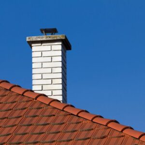 a white brick chimney on a red roof